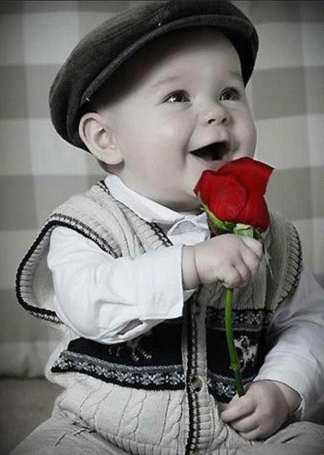 Cet adorable bambin souriant  ...  vous offre une rose !